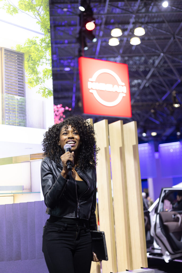 Automotive Product Specialist with microphone at new york auto show.