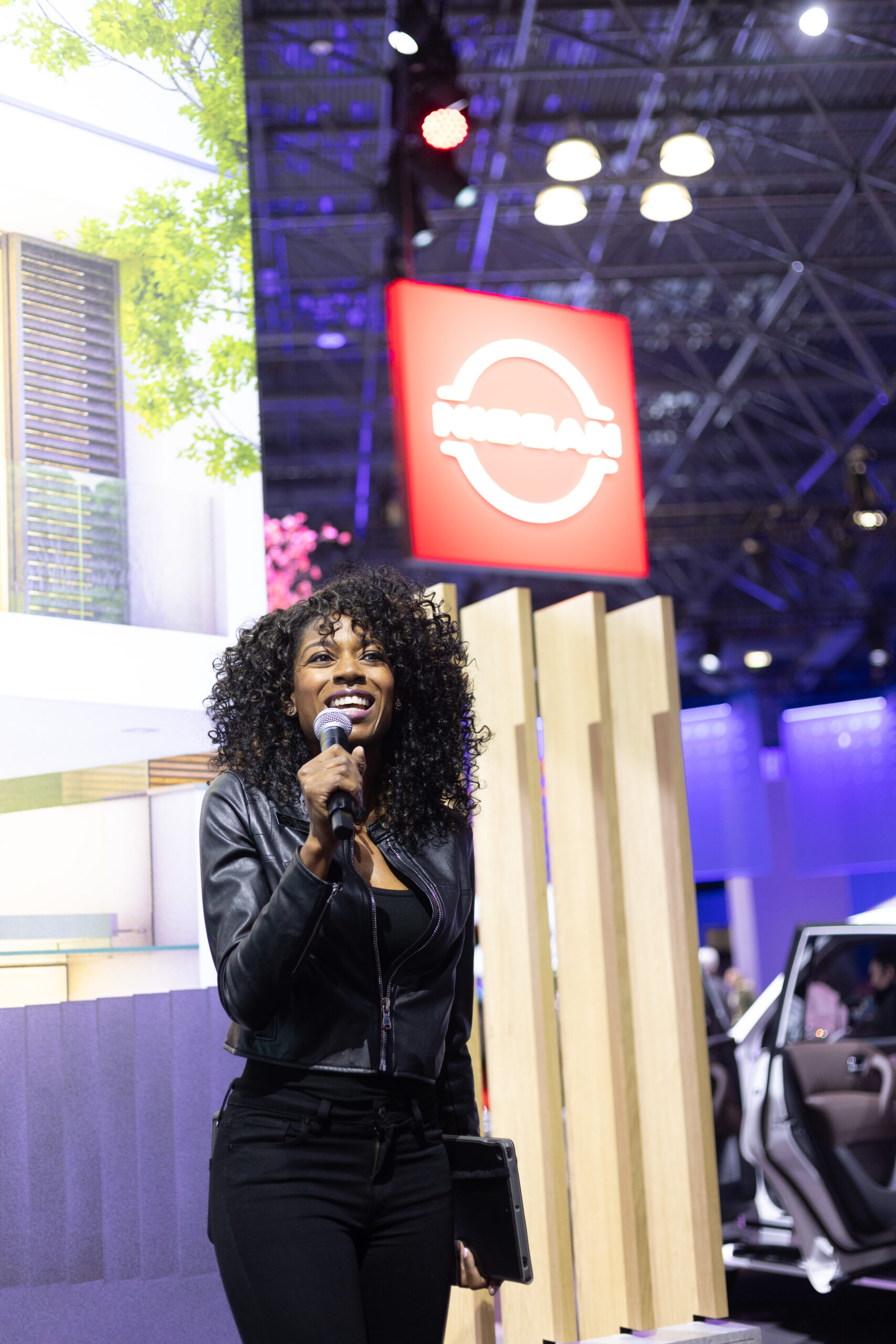Automotive Product Specialist with microphone at new york auto show.