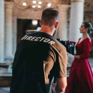 A director filming a woman in a red dress