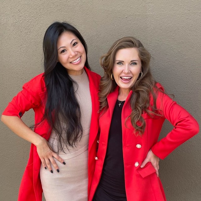 Two women in red jackets smiling at the camera.