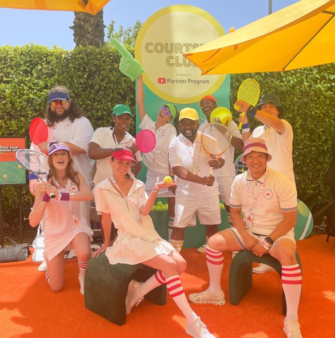 Talent in tennis outfits working an outdoor event